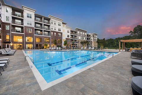 A large swimming pool in front of apartment buildings.