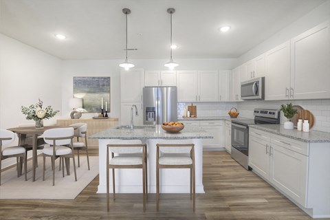 a kitchen and dining room with white cabinets and a marble counter top