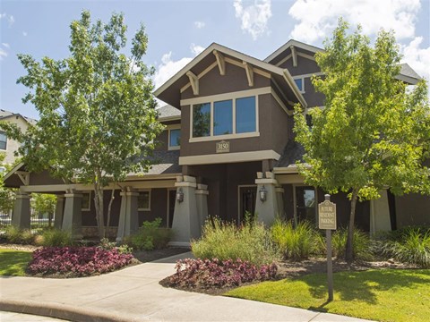 a house with a sidewalk and trees in front of it