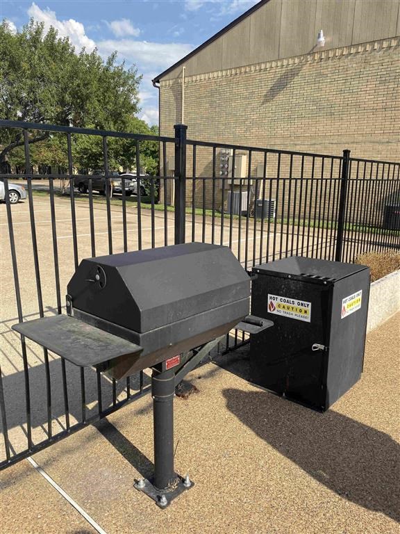 a grill and a table in front of a fence