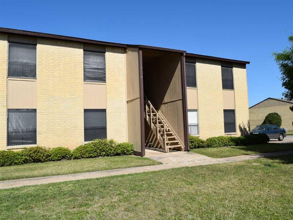 a yellow building with a staircase in front of it