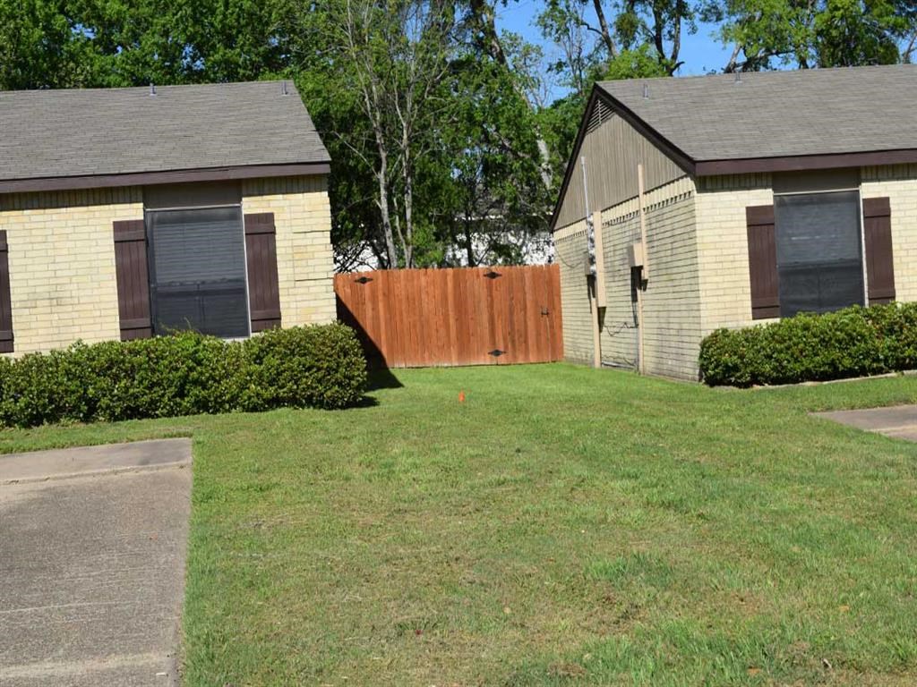 a house and a fence in front of a yard