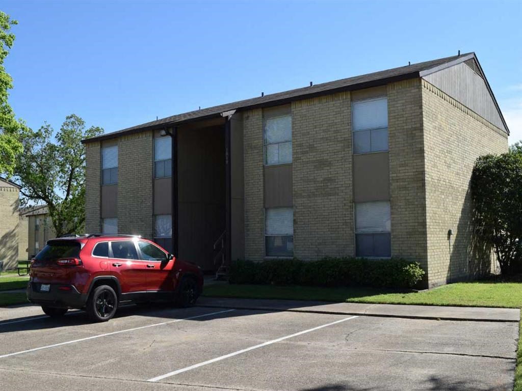 a red car parked in front of a brick building