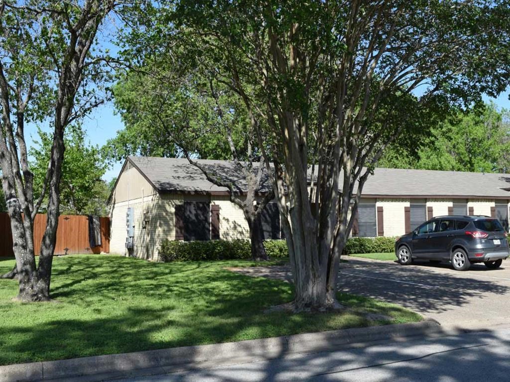 a house with a car parked in front of a tree