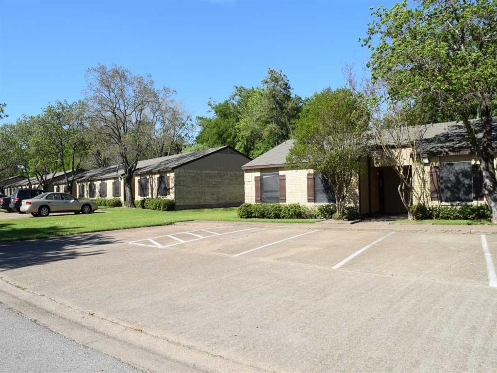 an empty parking lot in front of a row of houses