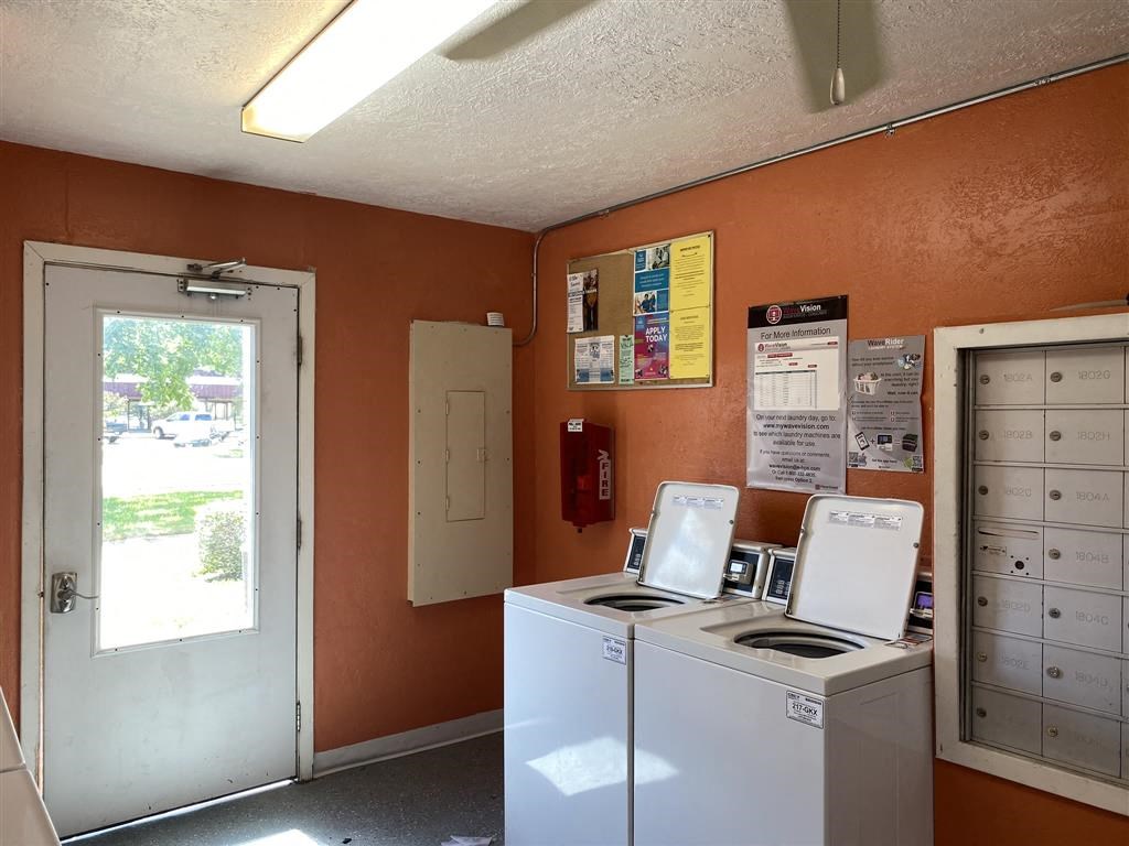 a kitchen with two washing machines and a door
