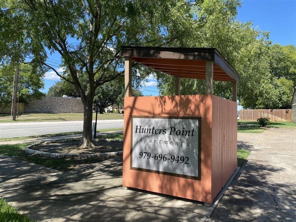 a sign for hunters point on the side of a road