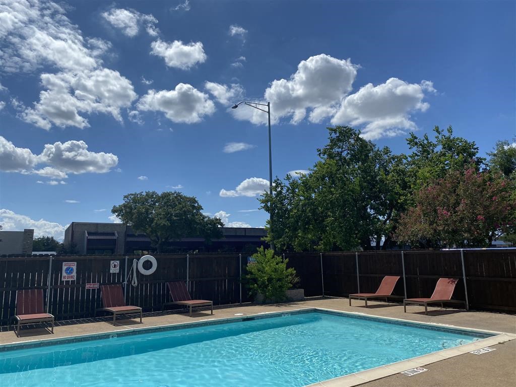 a swimming pool with chairs and a fence around it