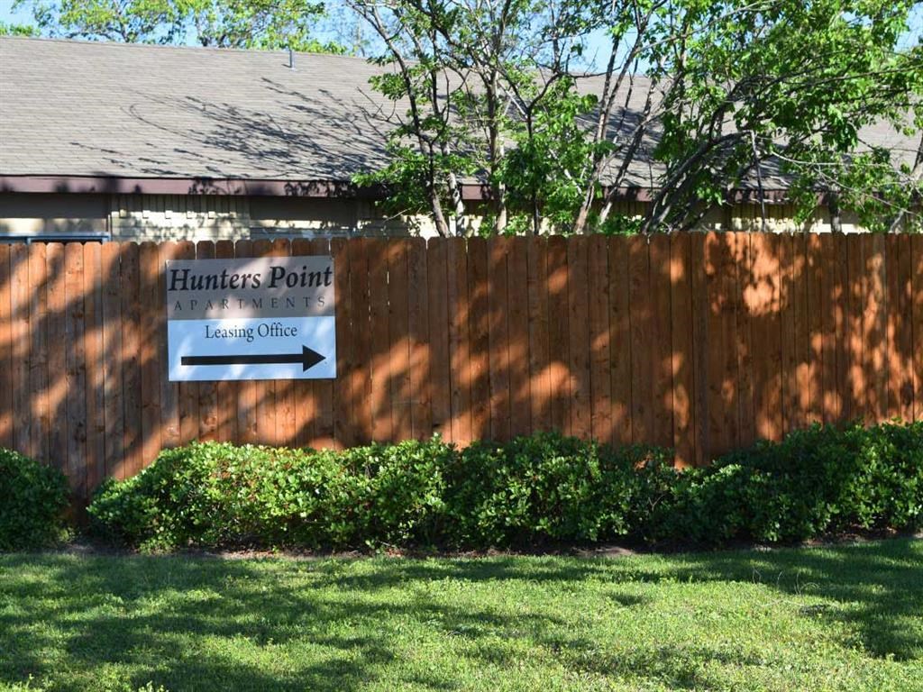 a wooden fence with a sign for hennessy point in front of a house