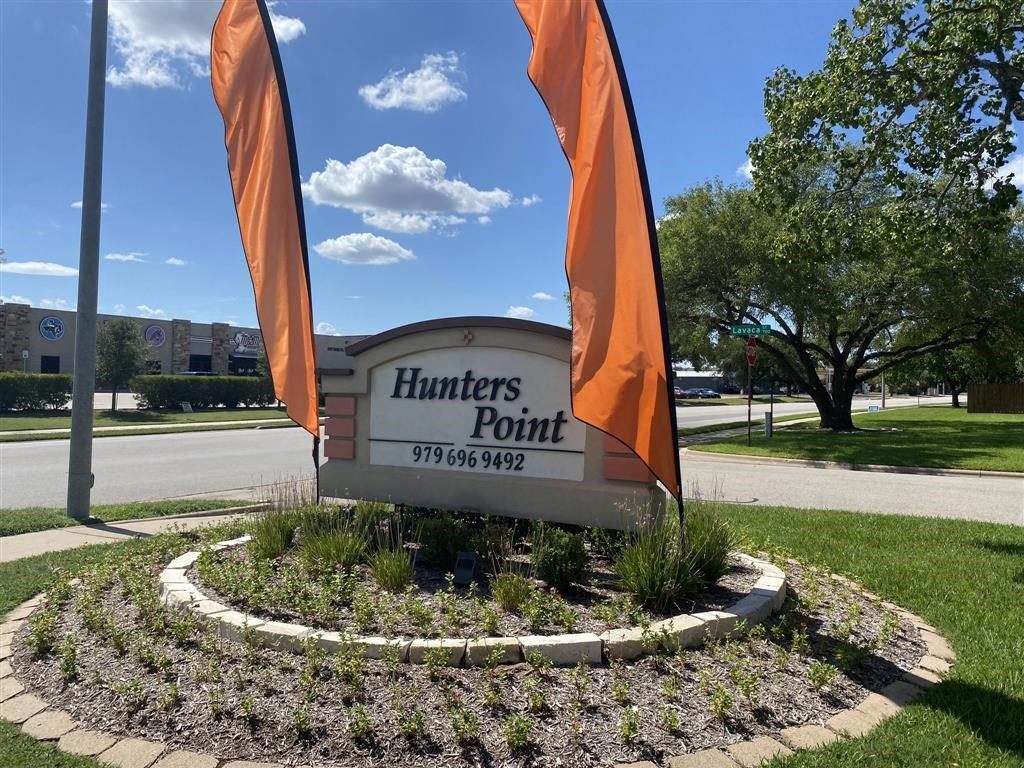 a sign for hunters point on the side of the street