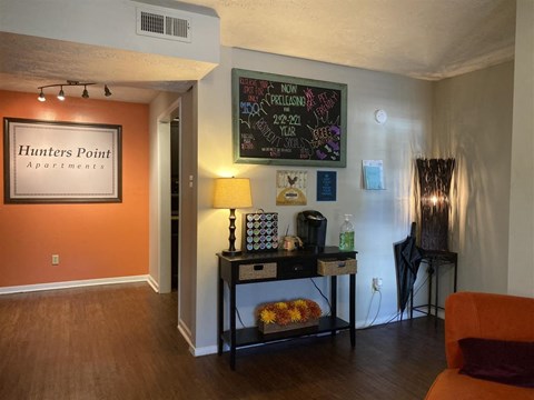a living room with a table and a chalkboard on the wall