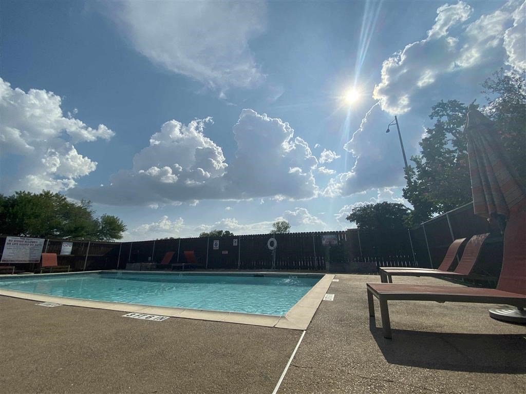 a swimming pool with two chairs next to it