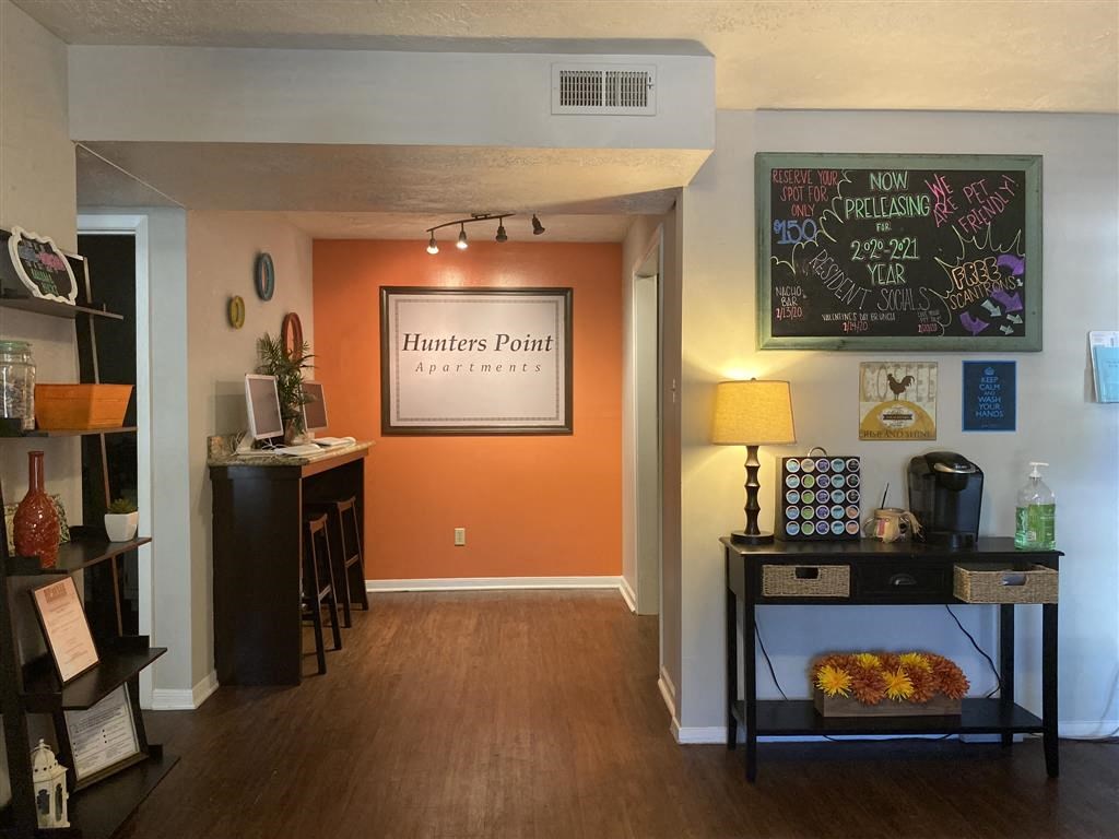 a living room with an orange accent wall and a dining room table