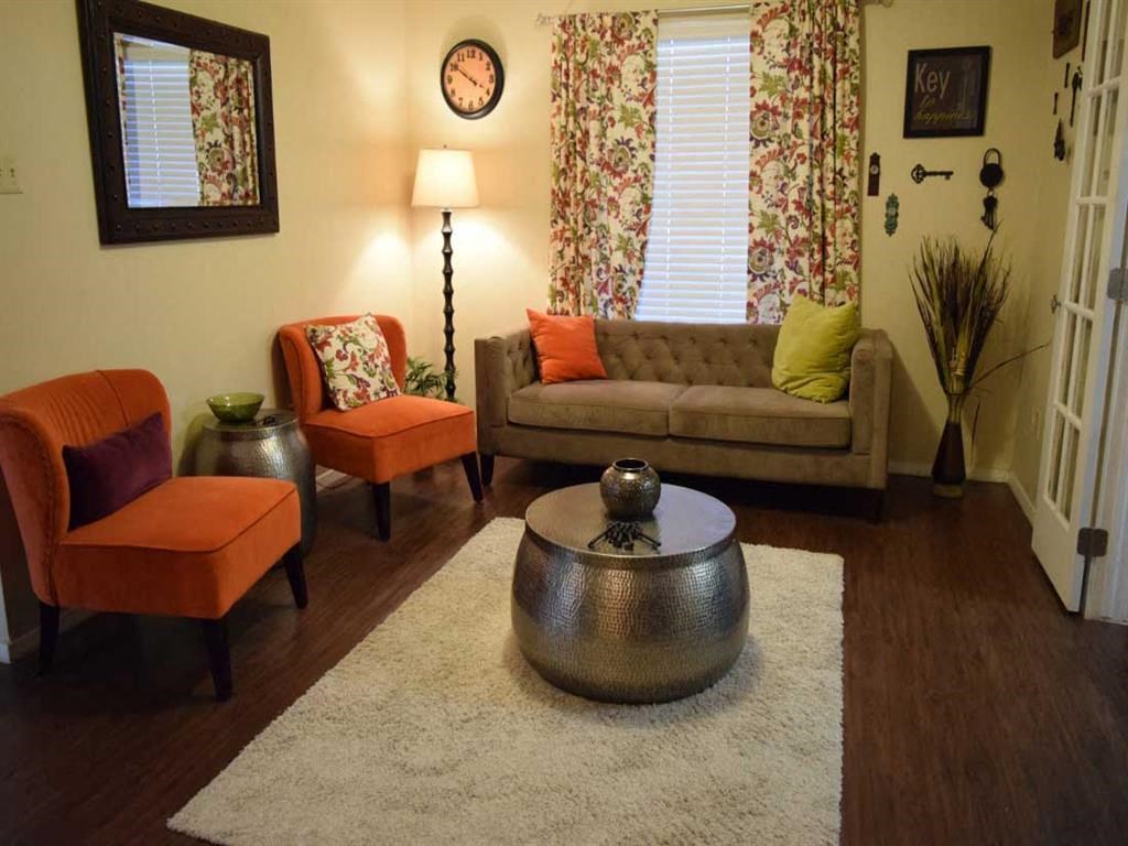 a living room with a couch and chairs and a rug