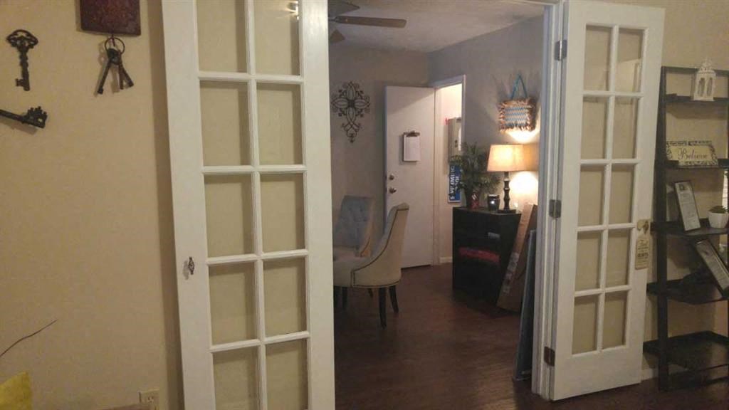 a living room with white doors and a dining room