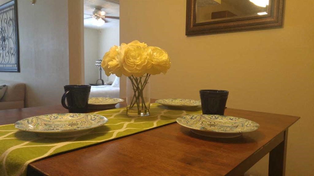 a dining room table with plates and a vase with flowers