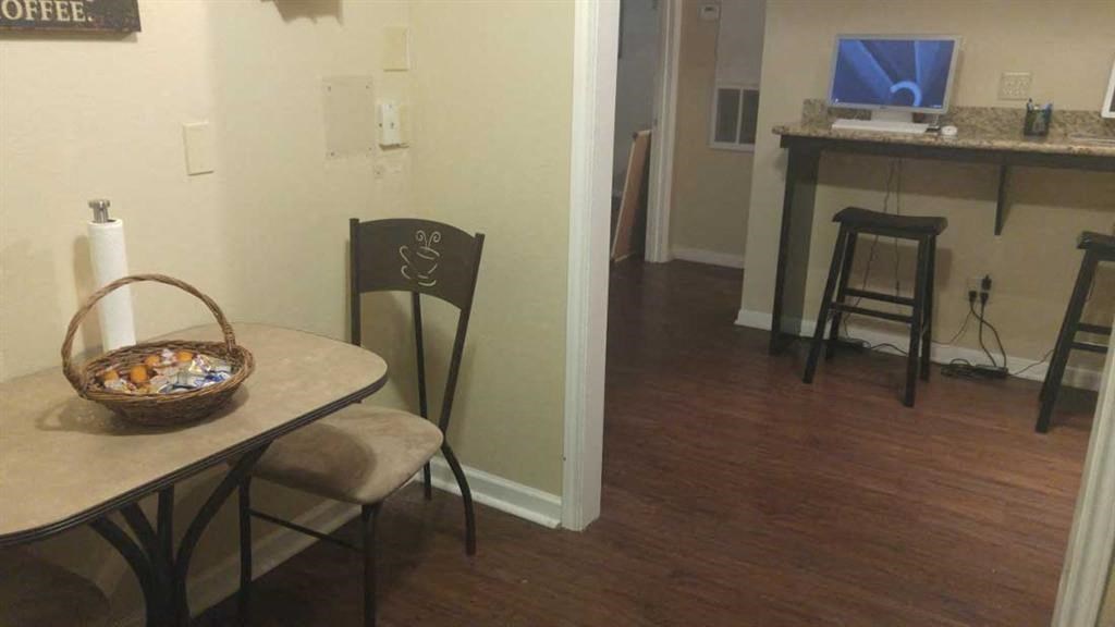 a living room with a table and chairs and a computer