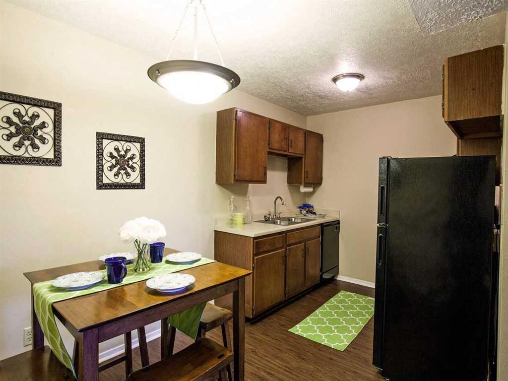 a kitchen with a dining table and a black refrigerator