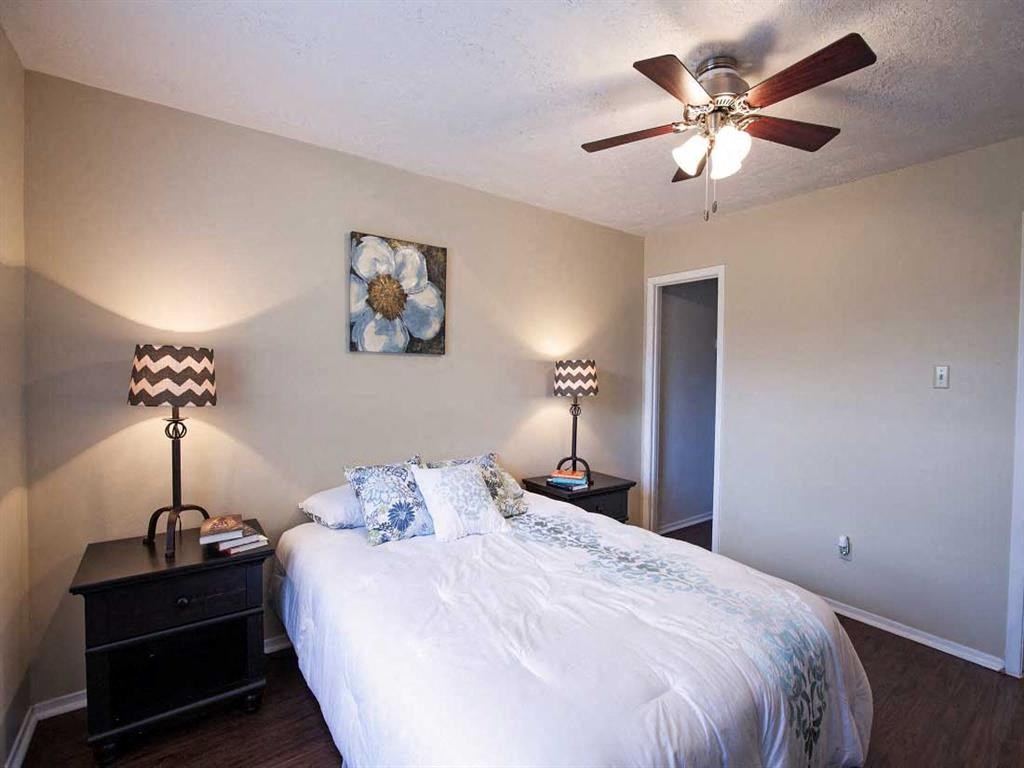 a bedroom with a large bed and a ceiling fan