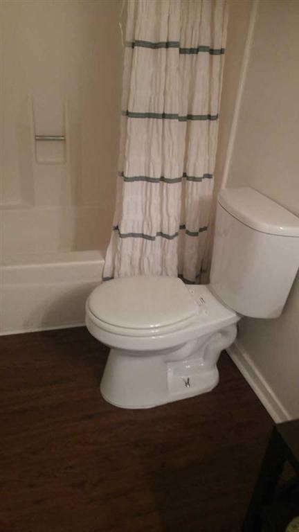 a bathroom with a toilet and a shower curtain