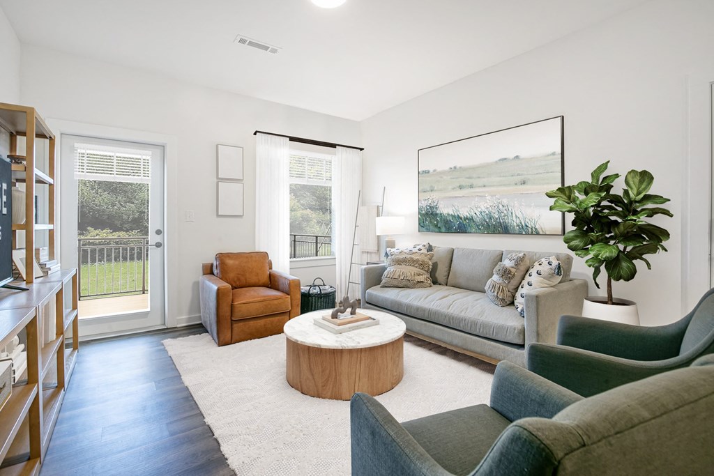 a living room with couches and chairs and a rug