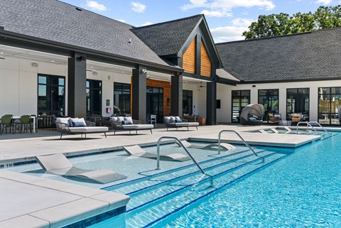 A large indoor swimming pool with a diving board.