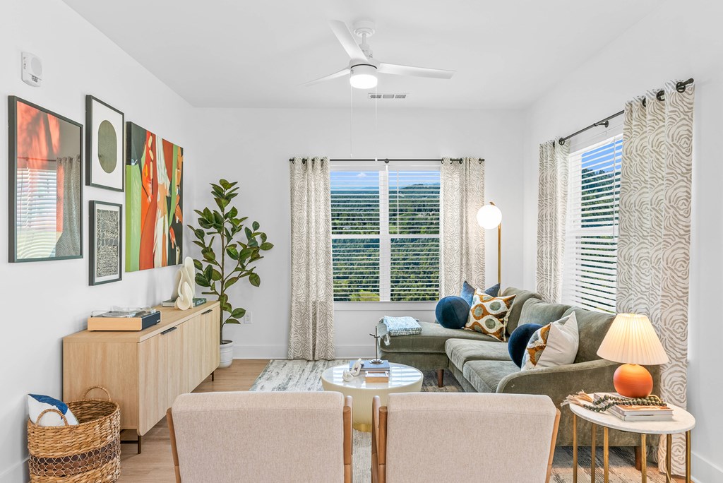 A living room with a couch, chair, and a table with a lamp on it.