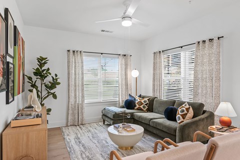 A living room with a grey couch and a wooden side table.