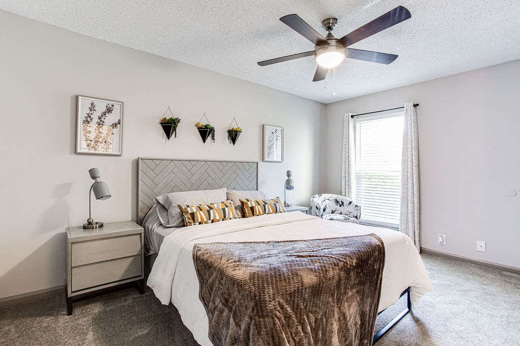 a bedroom with a large bed and a ceiling fan  at The Laurel, Union City, Georgia
