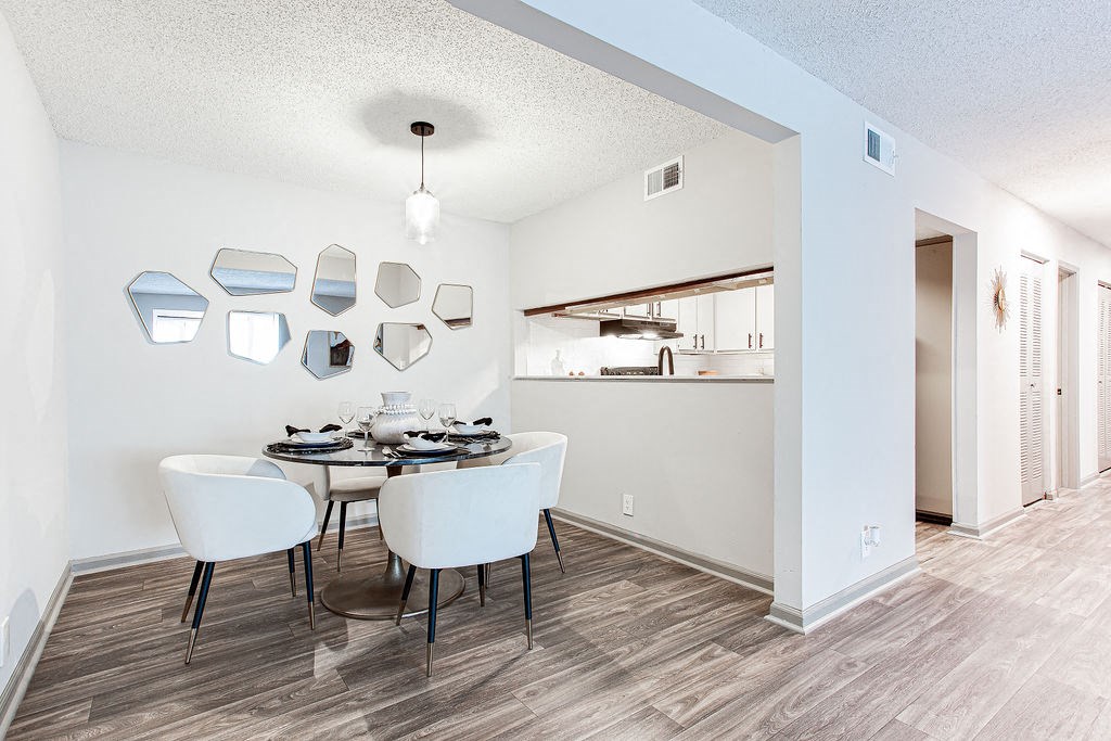 a dining area with a table and chairs and a kitchen in the background at Hidden Lake, Georgia