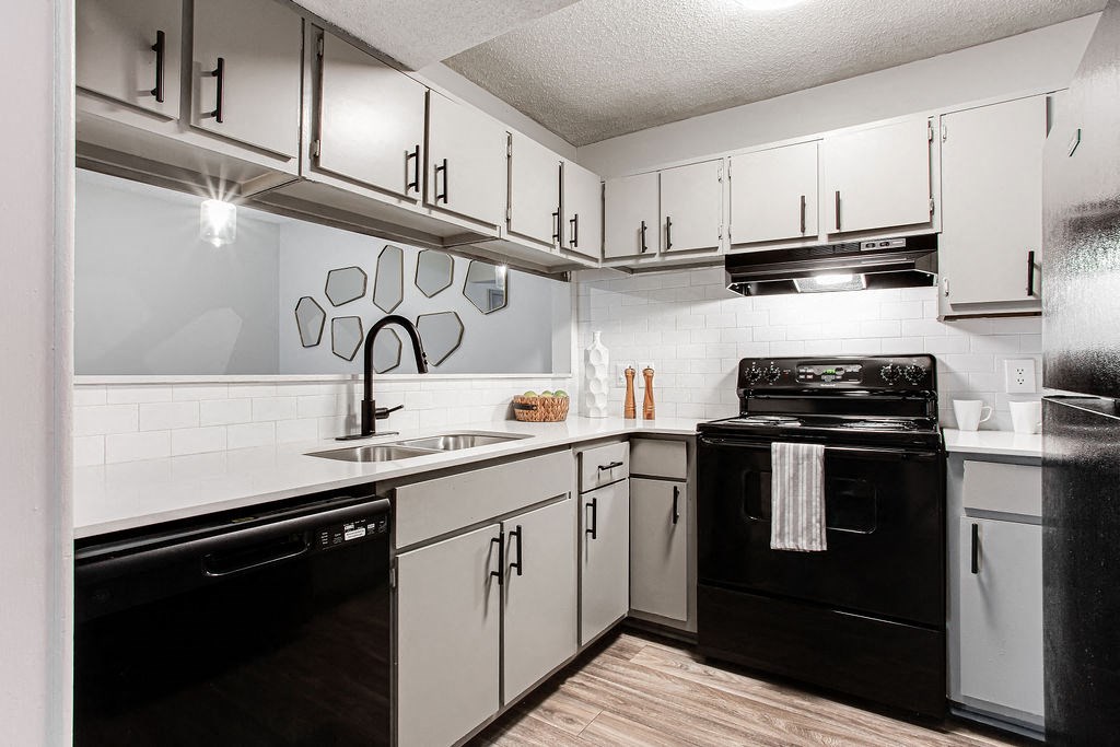 a kitchen with white cabinets and black appliances at Hidden Lake, Union City, GA