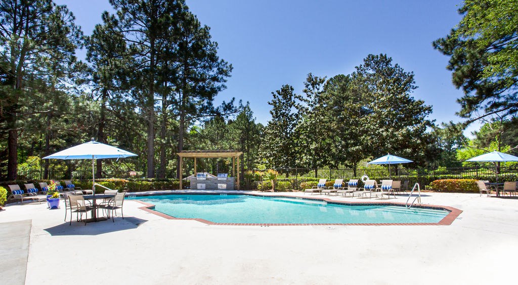 a swimming pool with chaise lounge chairs and umbrellas at Hidden Lake, Union City, GA