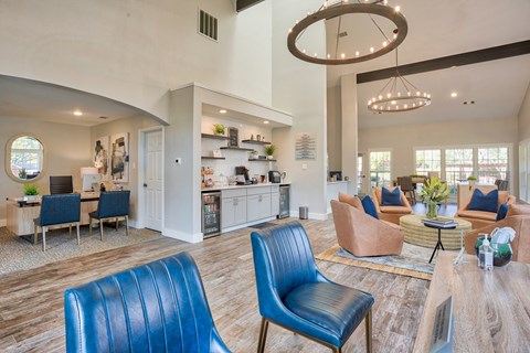 A living room with blue chairs and a wooden floor.