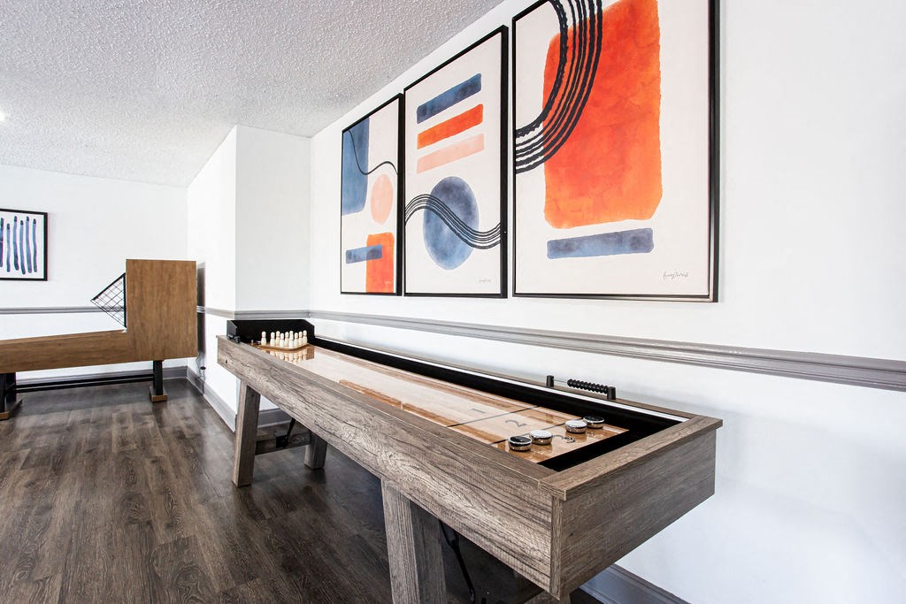 a pool table in a living room with art on the wall