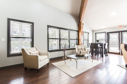 a living room with chairs and a table in front of windows