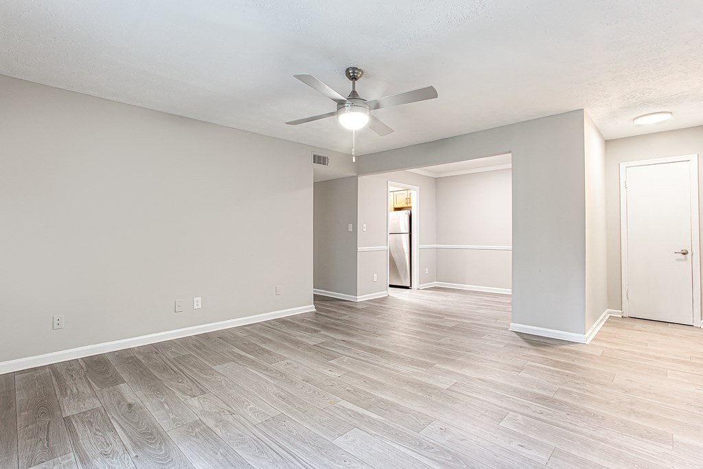 an empty living room with a ceiling fan and wooden flooring at The Ellis Apartments, Clarkston, 30021