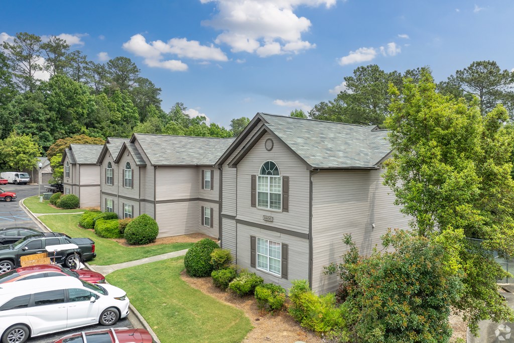 a gray house with cars parked in a parking lot
