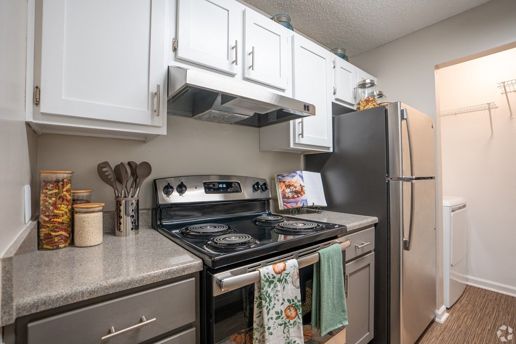 an updated kitchen with stainless steel appliances and white cabinets