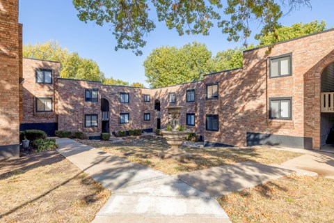A courtyard surrounded by brick buildings on a sunny day.