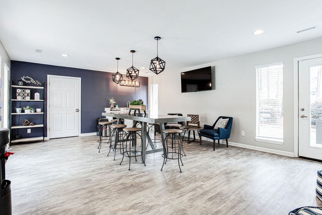 a room with a large table with chairs and a tv on the wall at Lory of Harbison, Columbia, SC