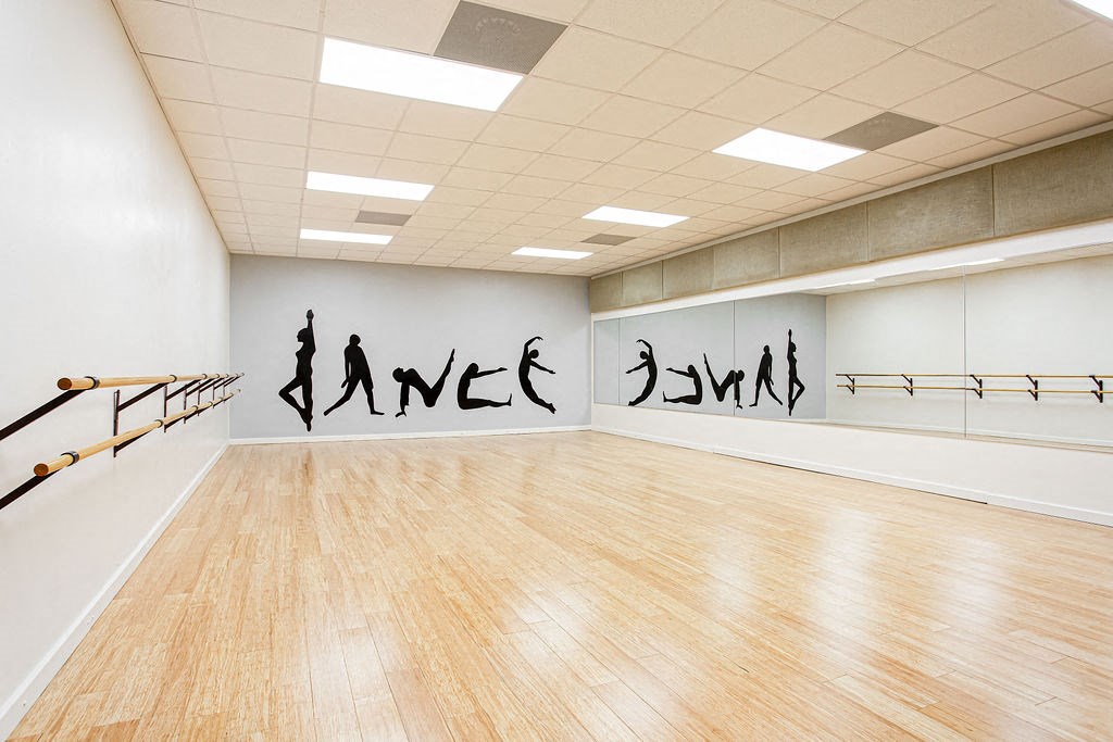 a large room with a wooden floor and a large mural on the wall at Lory of Harbison, Columbia