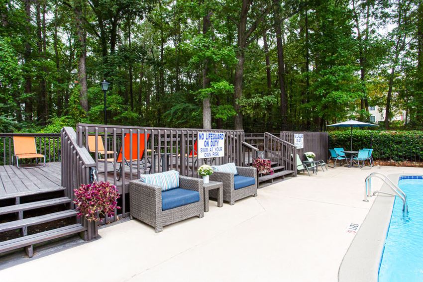 a large deck with chairs and a swimming pool