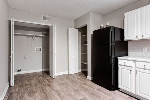 a kitchen with a black refrigerator and white cabinets