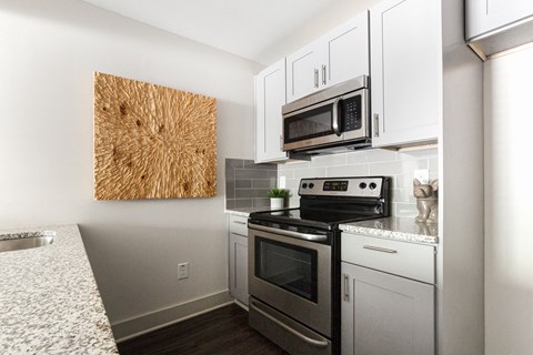 a kitchen with stainless steel appliances and white cabinets