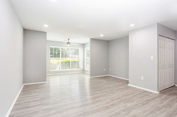 an empty living room with grey walls and a window