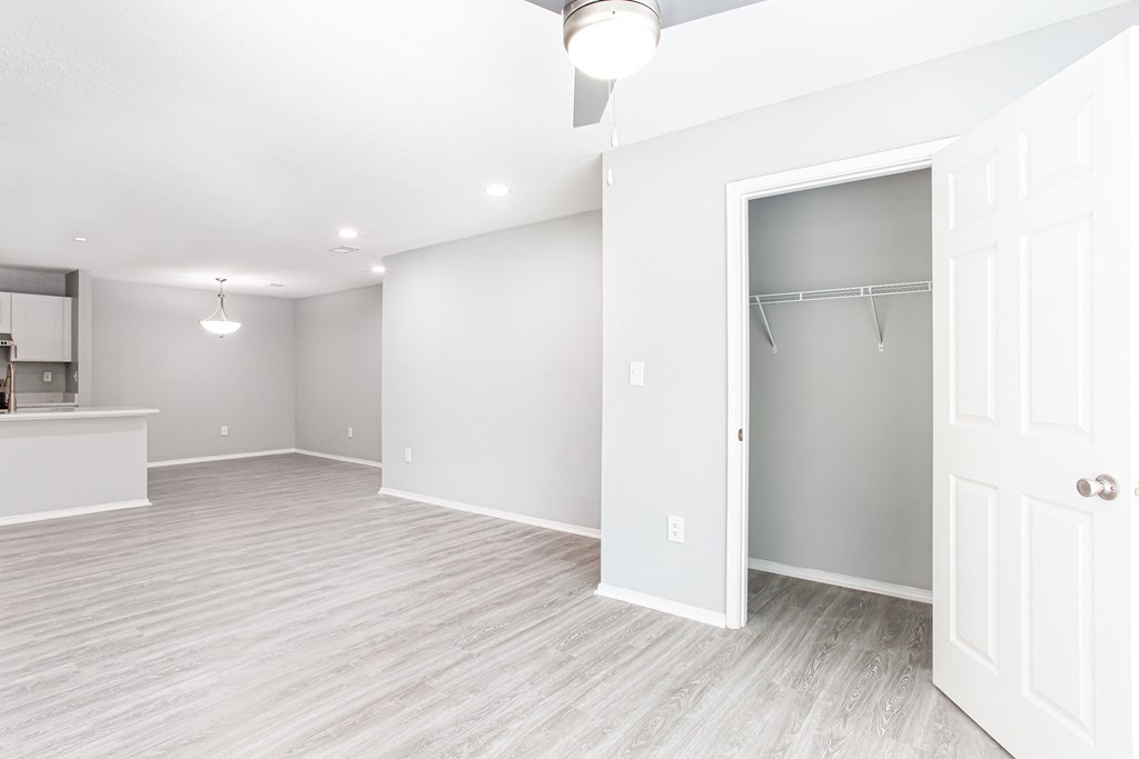 an empty living room with a closet and a kitchen at Parc at 1875, Georgia