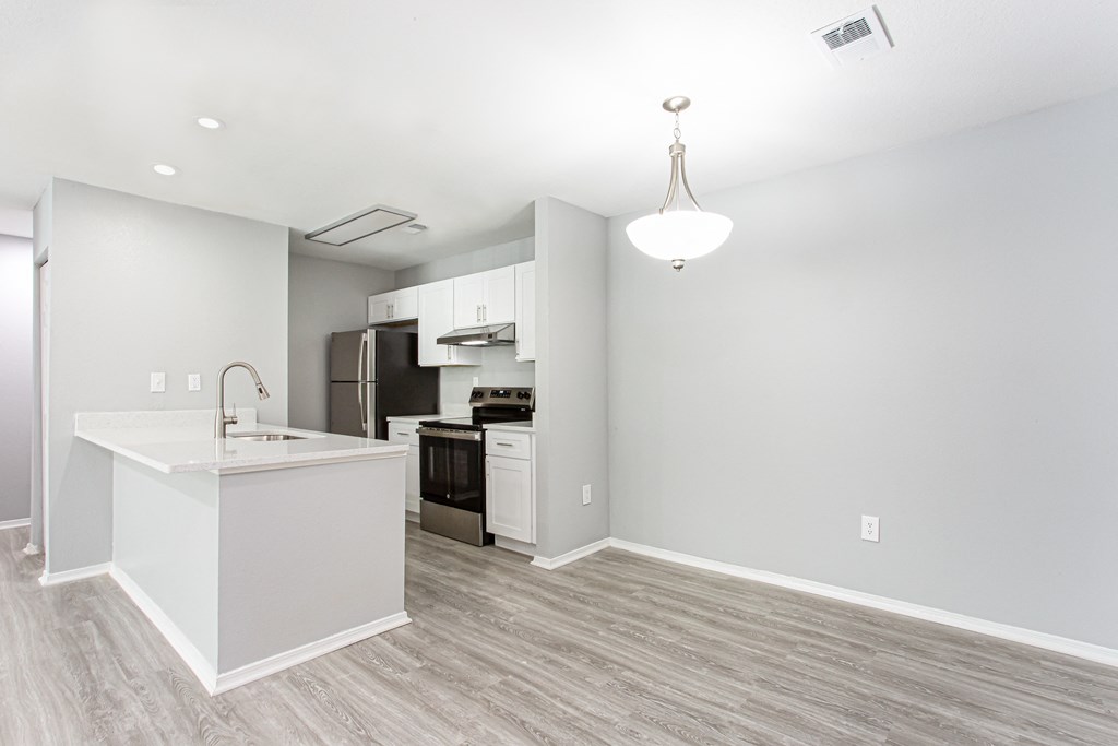 an empty apartment with a kitchen and a counter top at Parc at 1875, College Park