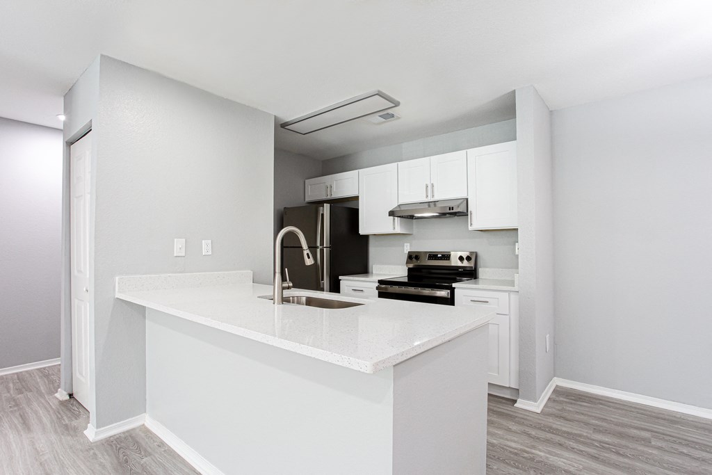 an empty kitchen with white cabinets and a white counter top at Parc at 1875, College Park