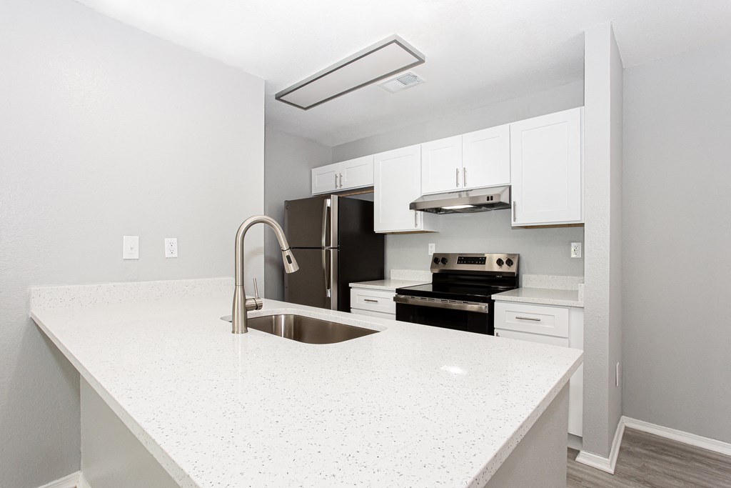 a kitchen with white counter tops and a sink at Parc at 1875, College Park, GA