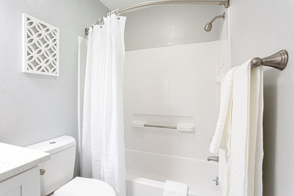 a white bathroom with a white shower curtain and a toilet  at Parc at 1875, College Park, Georgia